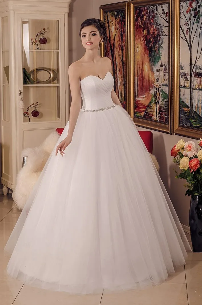 ---Princess wedding dress in satin and tulle with pleated bodice with padded cups, an important jewel belt at the waist--